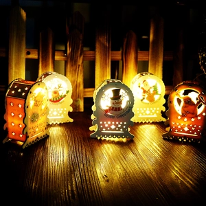 Close-up of white wooden LED Christmas houses with warm lights and festive carvings