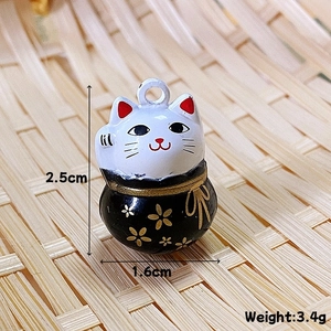 Dettaglio macro del ciondolo Maneki Neko da 2,5 cm con motivo a fiori di prugno