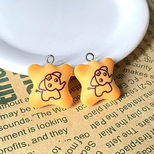 Détail macro de pendentifs éléphants en résine jaune avec anneaux en métal
