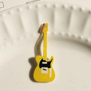 Detalle macro de un colgante de guitarra eléctrica amarilla en acrílico para joyería DIY