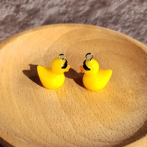 Makroaufnahme der niedlichen gelben Enten aus Harz mit Sonnenbrille für DIY-Schmuckzubehör