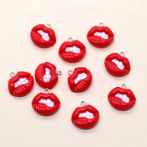 Macrodetail van rode hars lippenhangers met witte tanden en zilveren metalen ringen