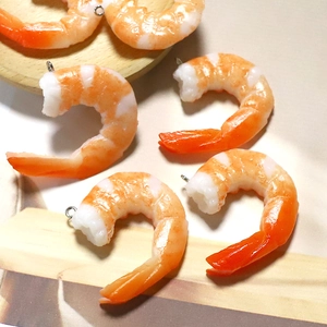 Macro shot of hyper-realistic resin shrimp pendants with silver hooks for DIY jewelry