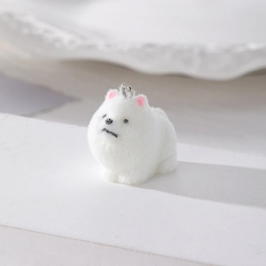 Dettaglio del ciondolo cane Pomerania bianco floccato con orecchie rosa e gancio