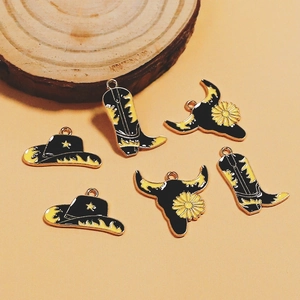 Detail of enamel cowboy boot, hat, and bull skull pendants for DIY jewelry making