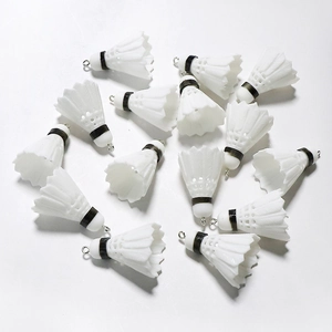Macro shot of miniature PVC shuttlecock pendants with silver metal rings for DIY sports jewelry