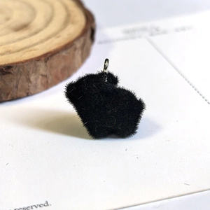 Detail of black flocked animal pendant with silver ring and soft velvety texture