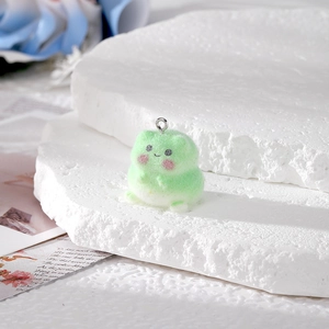 Cute light green flocked frog pendant with silver keychain ring on stone background