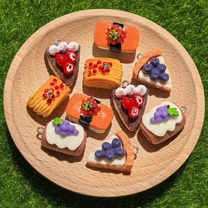 Set di ciondoli in resina a forma di cibo con sushi e torte su un vassoio di legno