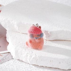 Cute flocked capybara pendant with red hat and blue headphones on stone display