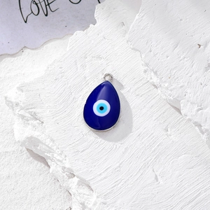 Macro di ciondolo occhio di Allah blu con bordo argento su pietra bianca ruvida