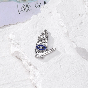 Dettaglio macro della mano di Fatima in argento con occhio blu e cristallo centrale