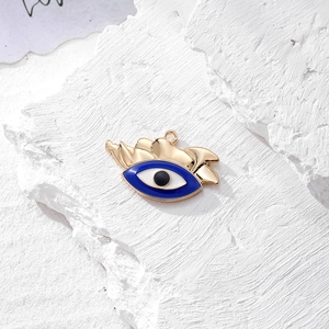 Dettaglio del ciondolo Evil Eye placcato in oro con smalto blu e zircone su roccia bianca