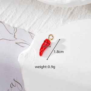 Vista macro del ciondolo peperoncino in smalto rosso con gancio oro, 1,8cm x 0,5cm