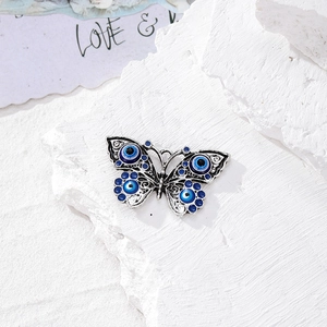 Dettaglio del ciondolo a farfalla in argento vintage con motivi a occhio blu per gioielli DIY