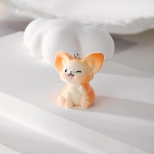 Macro shot of cute flocked fox pendant with soft fuzzy texture and silver jump ring