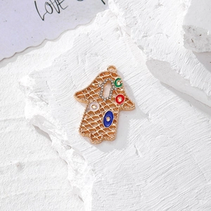 Dettaglio mano di Hamsa con strass e ciondoli smaltati colorati contro il malocchio