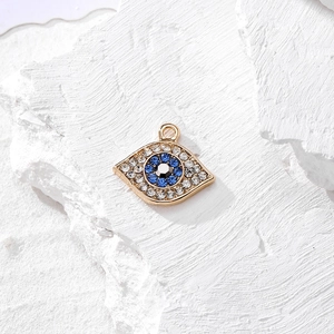 Dettaglio del ciondolo malocchio dorato con cristalli blu per la creazione di gioielli
