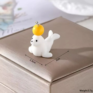 Detailed view of resin seal charm with dimensions 3cm by 2.3cm and metal ring attachment