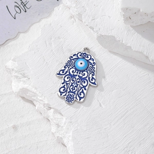 Dettaglio del ciondolo Mano di Fatima in argento con smalto blu e perla malocchio