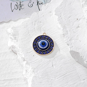 Dettaglio del ciondolo occhio turco con cristalli blu e finitura oro su pietra