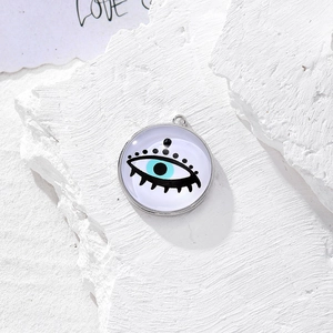 Dettaglio macro del ciondolo rotondo Evil Eye in argento su una pietra bianca materica