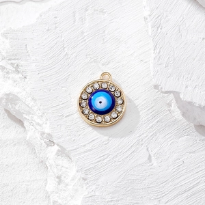Dettaglio del ciondolo malocchio dorato con strass blu brillanti per gioielli