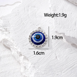 Dettaglio del ciondolo occhio greco con smalto blu e pavé di cristalli scintillanti