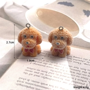 Dettaglio del ciondolo a forma di cane teddy floccato arancione con misure di 2,7x1,9cm
