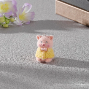 Détail d'un mignon pendentif cochon rose floqué portant un pull jaune pour bijoux DIY