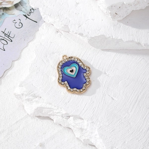 Dettaglio della Mano di Fatima con occhio a cuore blu e strass in cristallo dorato