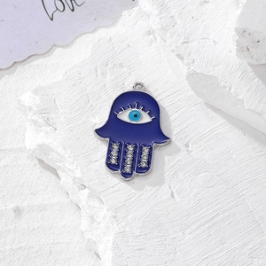 Dettaglio macro del ciondolo Mano di Fatima in smalto blu con occhio e strass