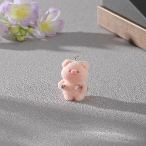 Détail d'un pendentif cochon rose floqué avec anneau métallique sur fond texturé