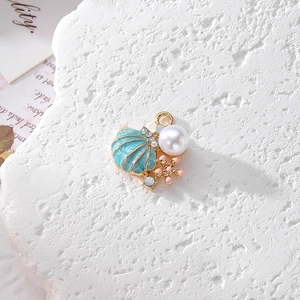 Makroaufnahme von blauem Emaille-Muschel-Anhänger mit Perle und Seestern für DIY-Schmuck