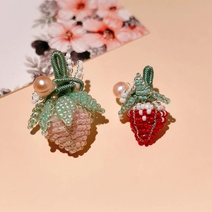 Detail of handmade beaded strawberry charms with faux pearls for DIY jewelry accessories