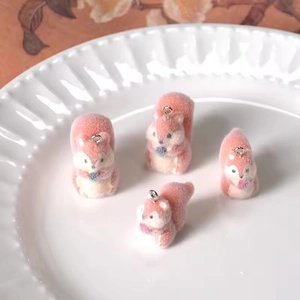 Cute pink and white flocked squirrel charms for DIY earrings and necklaces in a ceramic bowl