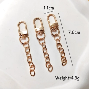 Three golden alloy swivel lobster clasps with chains, size 1.1cm x 7.6cm on white background