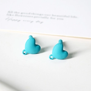 Detailed macro view of matte bright blue heart charms with ribbed edges and small loops