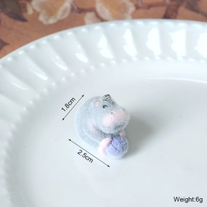 Vue macro d'un pendentif hippopotame floqué avec boule violette montrant la taille 1,8cm