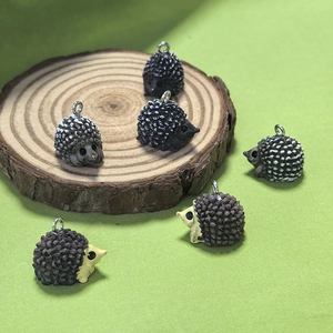 Gros plan de pendentifs hérisson en résine avec anneaux sur une tranche de bois naturel