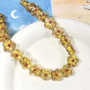 Détail de perles de fleurs colorées en verre avec feuille d'or pour bijoux DIY