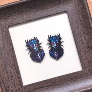 Detailed close-up of blue and purple acrylic dragon charms on a white textured background