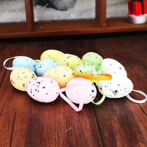 Macro detail of spotted foam Easter eggs with colorful hanging ribbons on wooden background