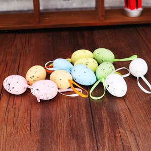 Colorful speckled foam Easter eggs with matching ribbons on a rustic wood background