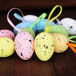 Close-up of spotted foam Easter eggs with colorful ribbons on dark wood surface