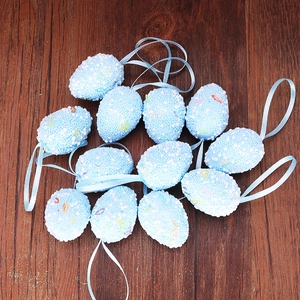 Set of light blue Easter foam eggs with colorful speckles and ribbon hangers on wood