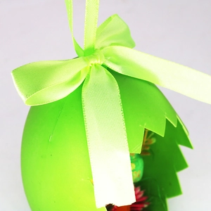 Detail of green Easter egg ornament featuring a satin bow and cracked shell design