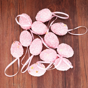 Set of 12 pink Easter foam eggs with glitter accents and ribbons on dark wood surface