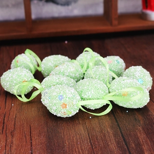 Detail of light green Easter eggs with foam texture, flower sequins, and hanging ribbons