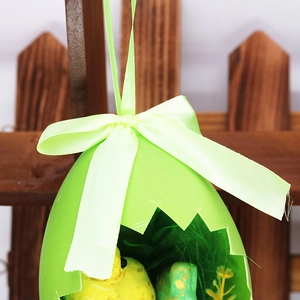 Close-up of Easter egg shell ornament with a small yellow chick and ribbon bow detail
